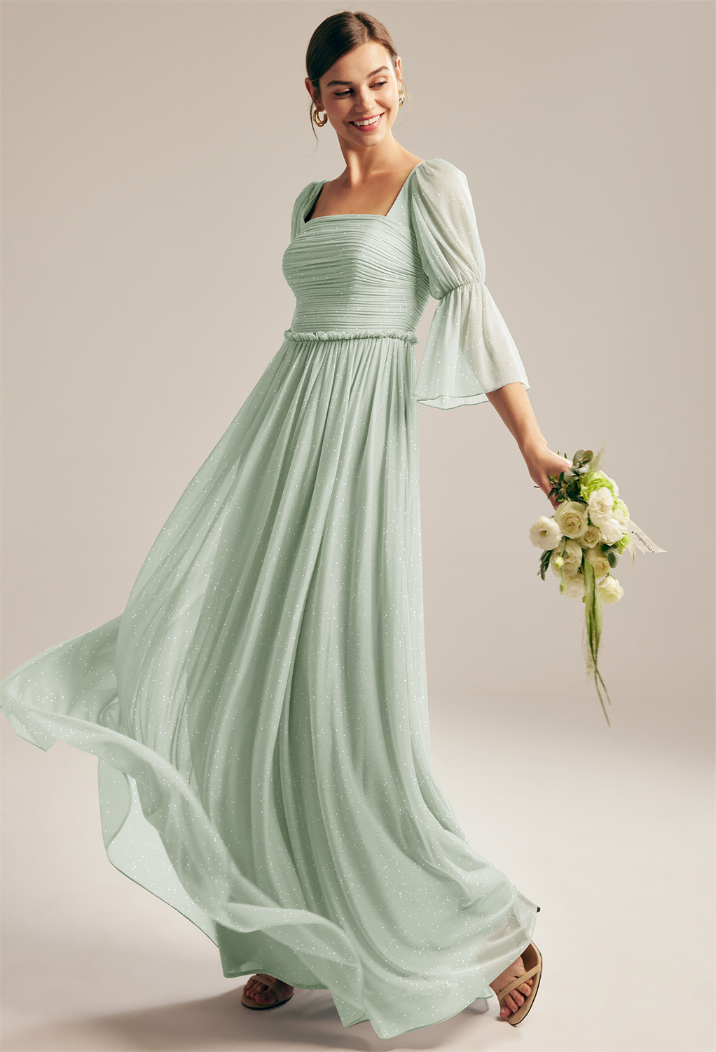 this square-neckline dress with moderately puffy shoulders and straight elbow-length arms is styled to provide a fine blend of the modern and classic look. It is a floor-length