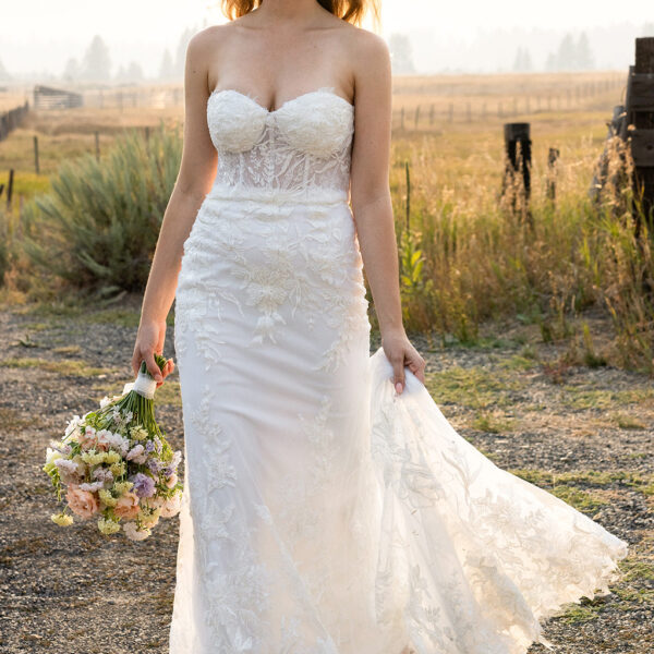 The AW Monica Wedding Dress is a dazzling gown and a worthy choice for a lady who wants to appear in a ravishing sleeveless and strapless lace wedding dress. It is designed with a mermaid silhouette and has a built-in bra. Styled with a sweetheart necklin