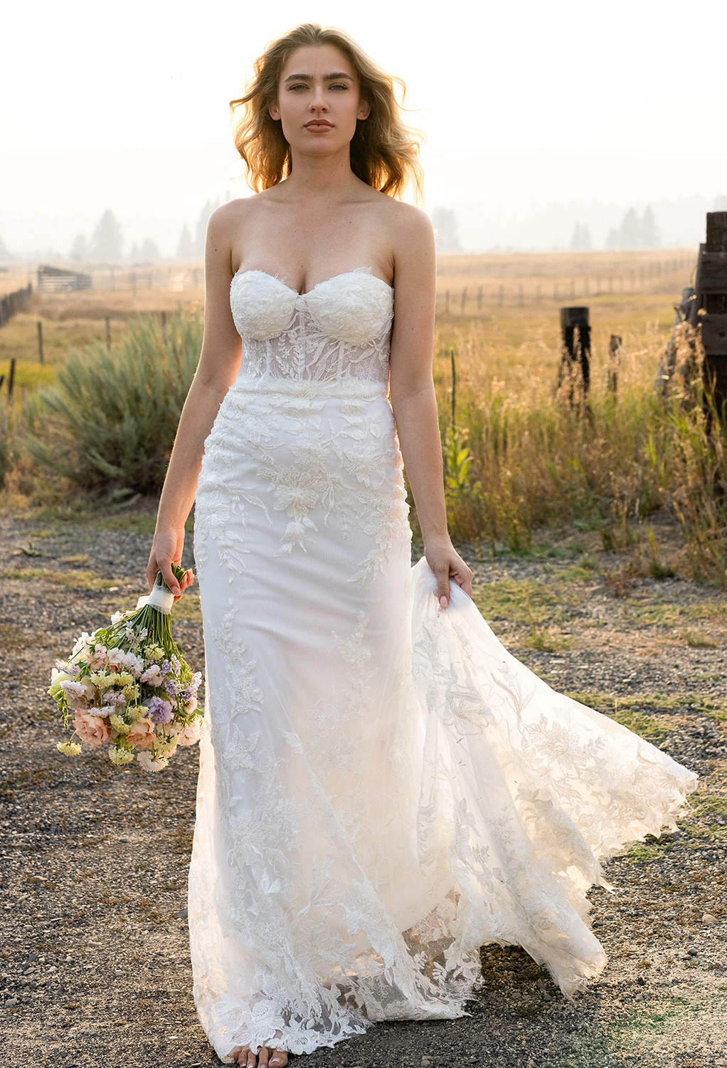 The AW Monica Wedding Dress is a dazzling gown and a worthy choice for a lady who wants to appear in a ravishing sleeveless and strapless lace wedding dress. It is designed with a mermaid silhouette and has a built-in bra. Styled with a sweetheart necklin