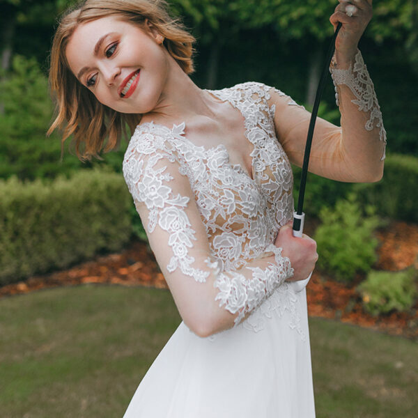 with a V-neckline. All decorated with elegant applique embellishments. The dramatic dip on the back of the dress is quite charming. The soft layered train will