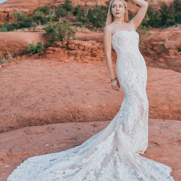 the Florina dress offers a sweetheart neckline that is very flattering. The dress features appliqued embellishments in a design that feels almost antique in inspiration. The train pools around the feet