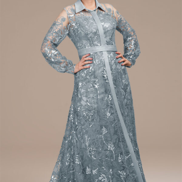 featuring a pristine slip under a sequined overlay. The V-neck descends into a central sash that elongates the figure