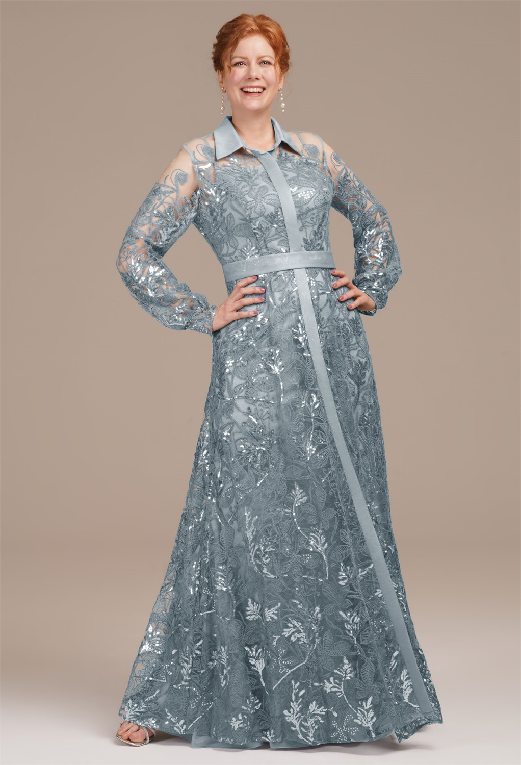 featuring a pristine slip under a sequined overlay. The V-neck descends into a central sash that elongates the figure