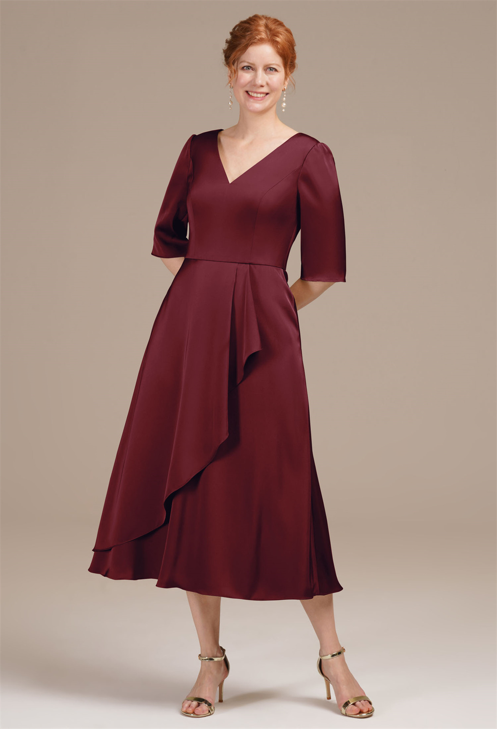 this tea-length A-line dress features a flattering V-neck and sophisticated elbow sleeves. Made from smooth satin charmeuse
