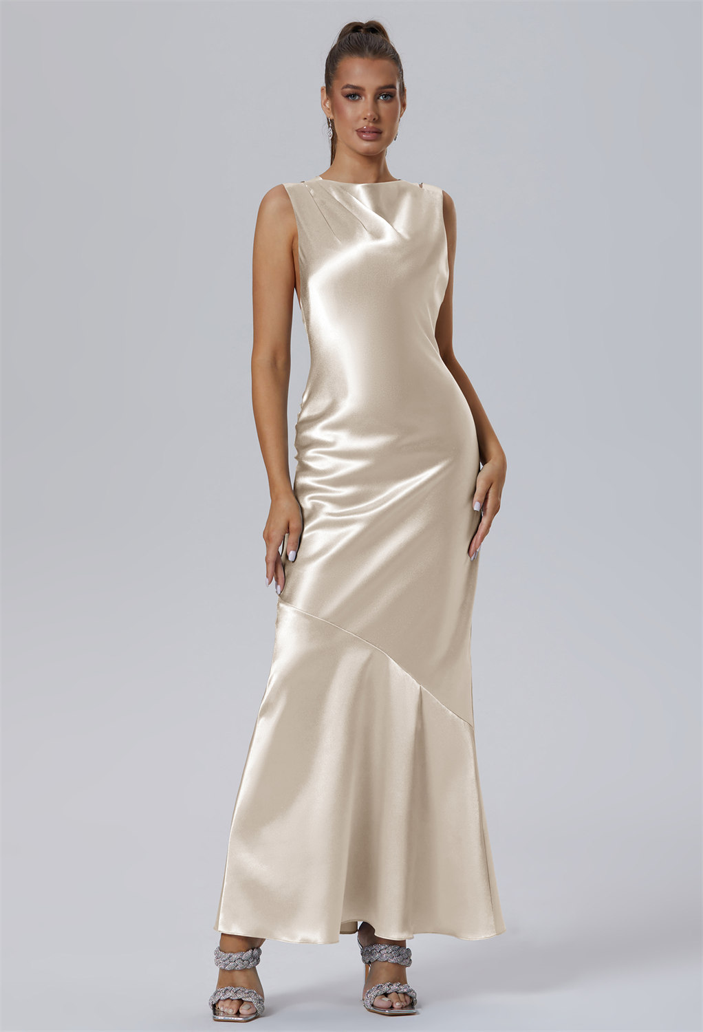 tailored in shimmering Crystal Satin. Its bateau neckline and sleeveless top are artfully balanced by distinctive straps draping down the back