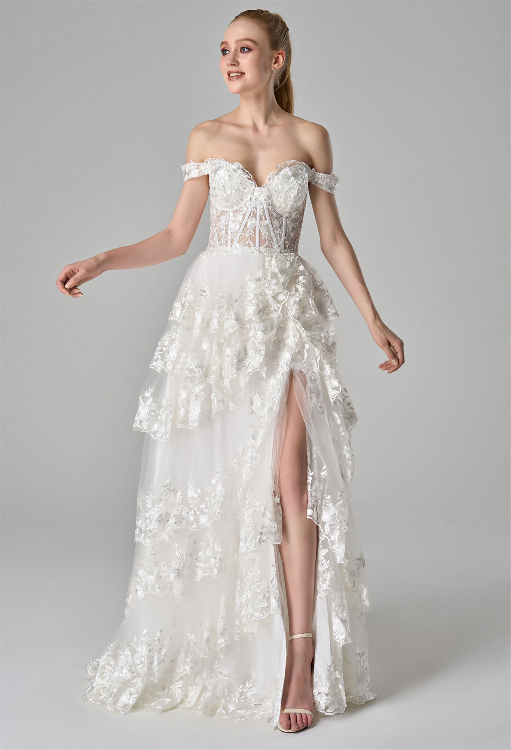 creating a romantic and voluminous silhouette. A high front slit adds a touch of allure