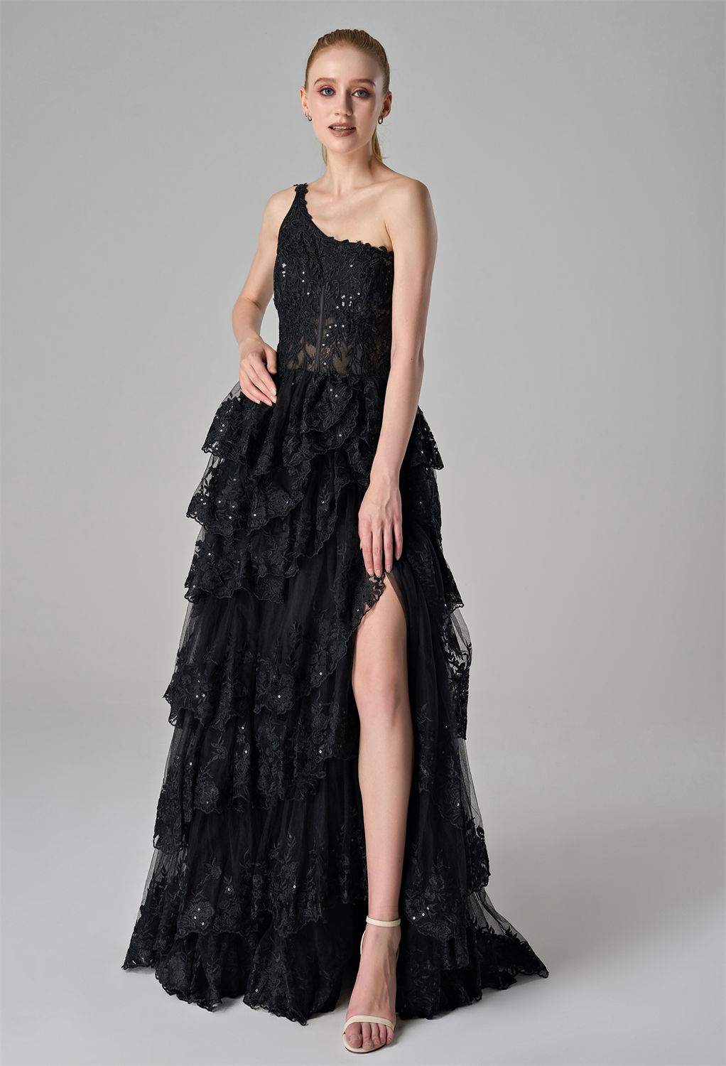 lace-embroidered bodice. The layered ruffle skirt with intricate lace detailing and a high slit adds a touch of drama and elegance