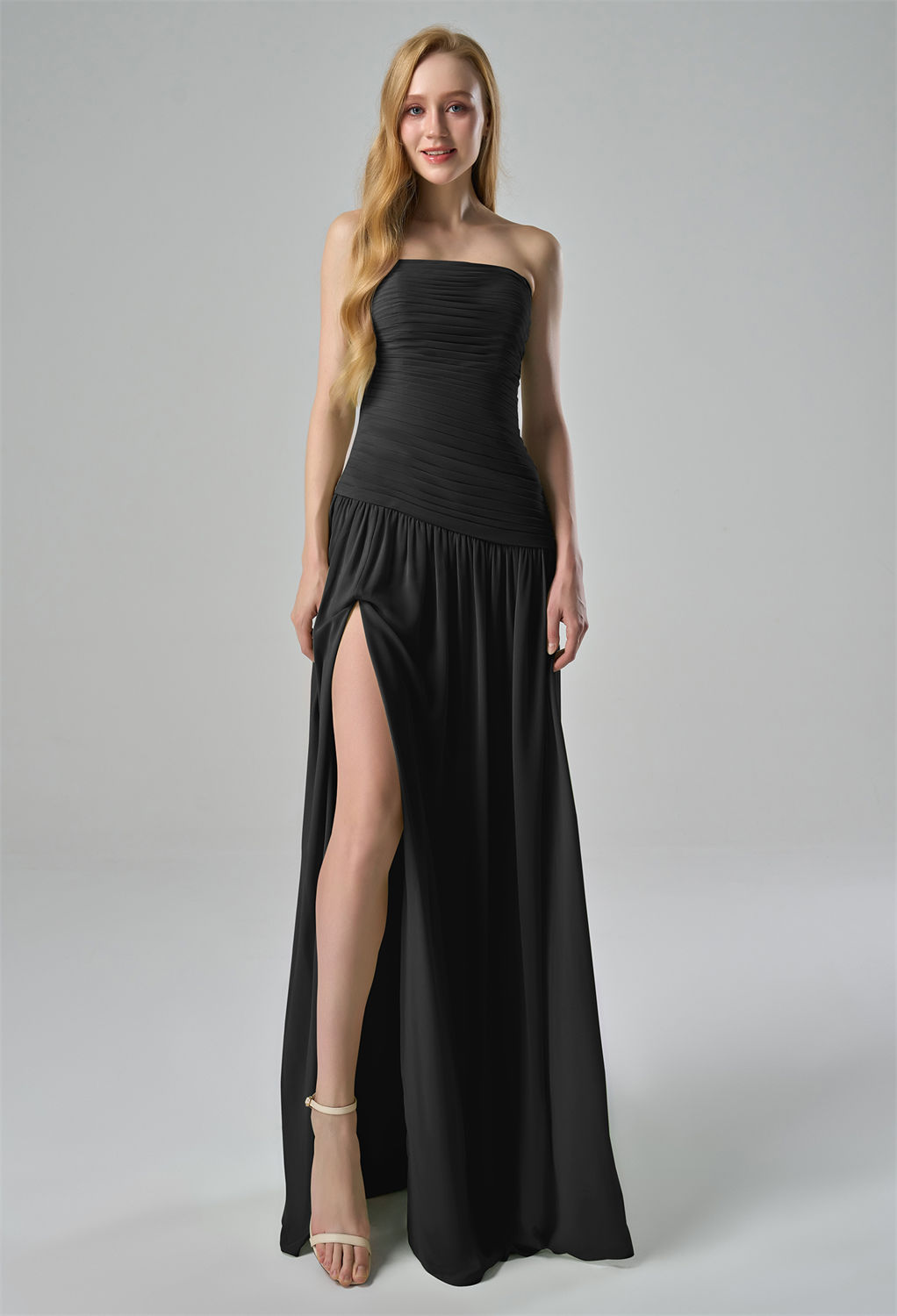 ruched bodice that elegantly accentuates the waist. The flowing skirt is designed with a high slit