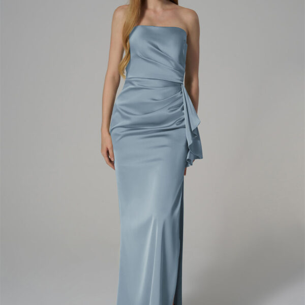 featuring a strapless neckline and a floor-length silhouette. The design is enhanced by elegant draping and a side slit for added sophistication. Crafted from high-quality satin fabric
