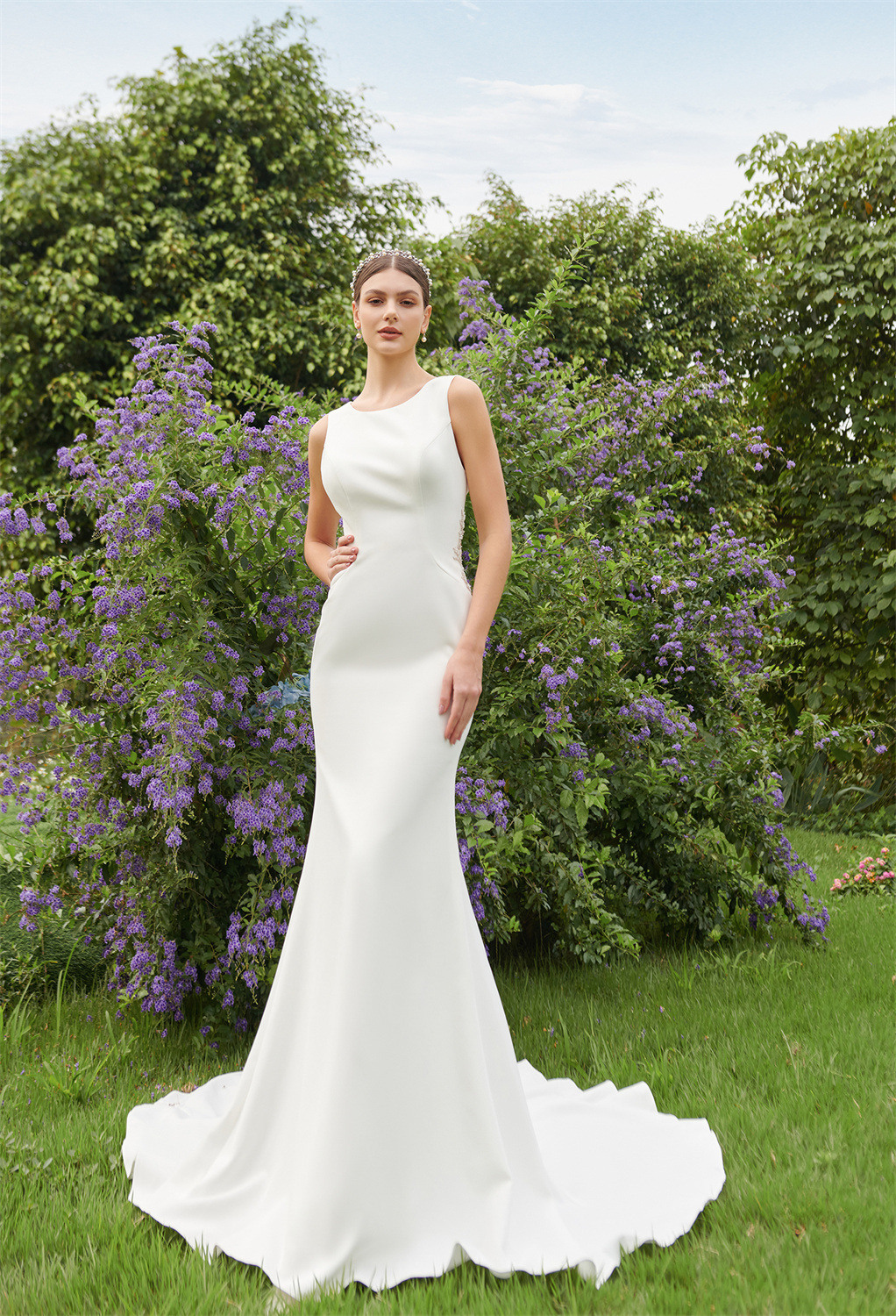 mermaid silhouette gown exudes a magnetic charm and cocoons the bride in a cloud of confidence. It features a jewel neckline bodice with a mesmerising open ba