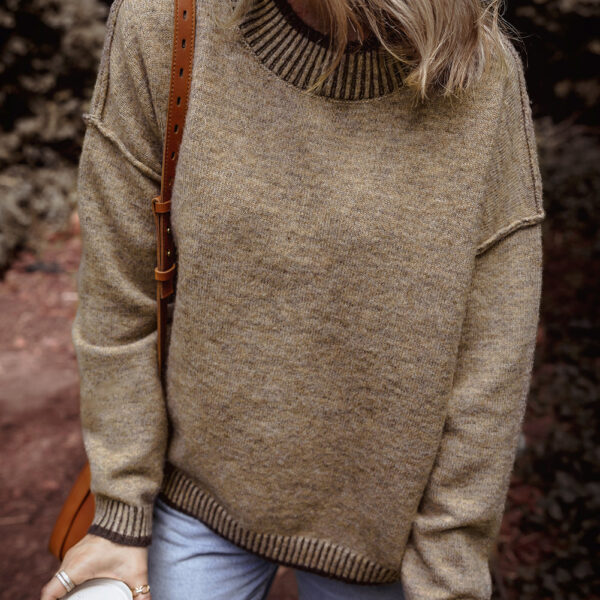 The River Contrast Trim Mock Neck Sweater boasts a sleek mock neck design for an added touch of elegance. With its trendy drop shoulder style