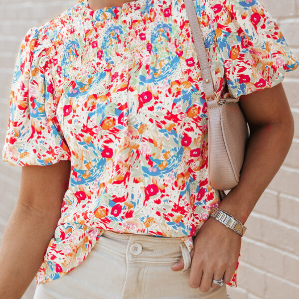 Get ready to fall head over heels for our gorgeously printed blouse! With a snazzy smocked neckline and darling short puff sleeves