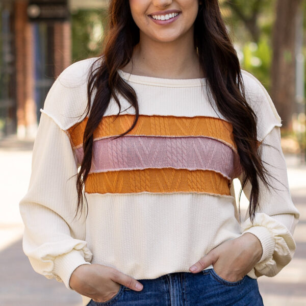 Get ready to turn heads in this standout corded top that boasts a one-of-a-kind textured appearance. Show off your love for artistry with a modern twist on traditional knit patchwork. Stay cozy and chic with fashion-forward drop shoulder sleeves