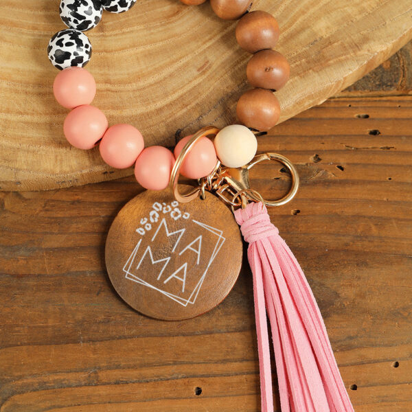 Get ready to make a statement with this MAMA Wood Pendant Leopard Fringe Keychain! Featuring a trendy mix of wooden beads and a playful tassel charm