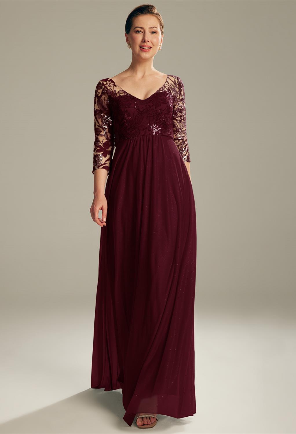 As a mom you can rock the wedding party with the AW Messi dress. The dress is made of glitter mesh with sequin adornment. The sleeves measure 3/4 in length. The V-neckline gives the dress a more fashionable look. The floor-length dress has a lined built-i